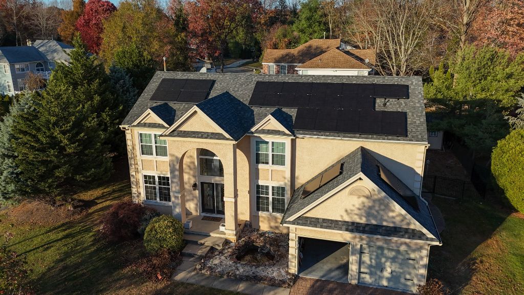 Aerial drone view of a completed solar installation on a stucco two-story home